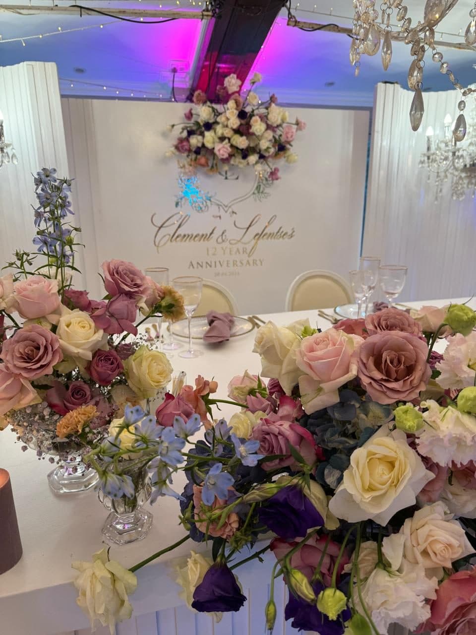 Gold anniversary backdrop framed by soft pink and blue blooms