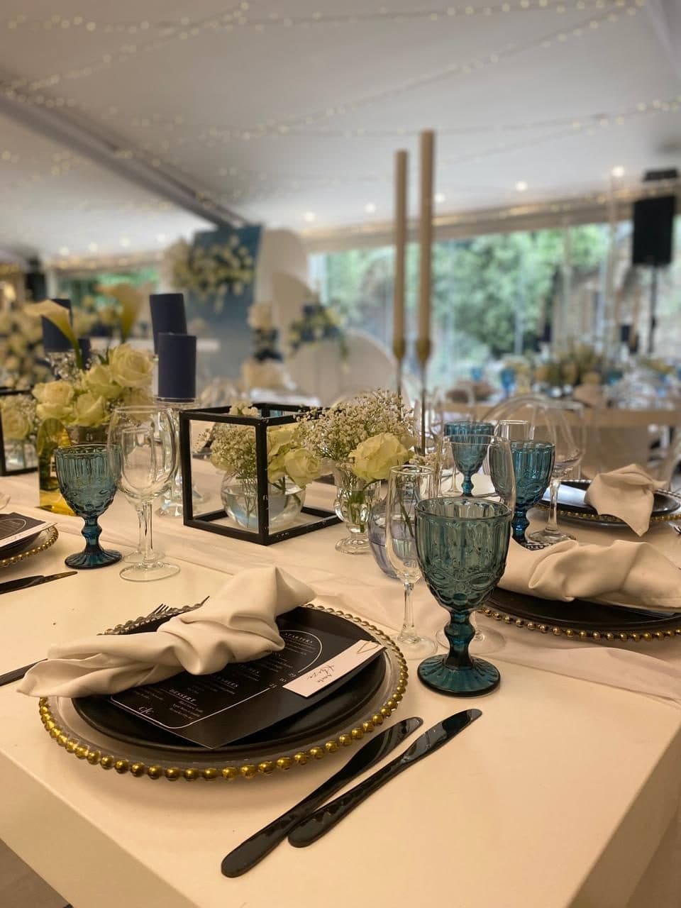 Place setting with beaded charger, printed menu and teal glassware