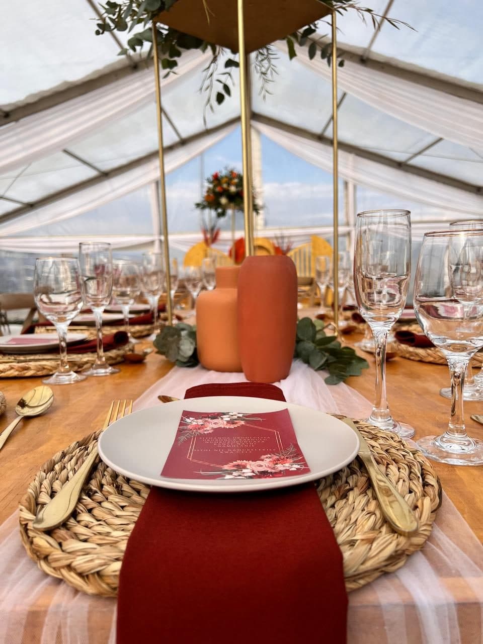 Place setting with woven charger, burgundy napkin and a printed menu card
