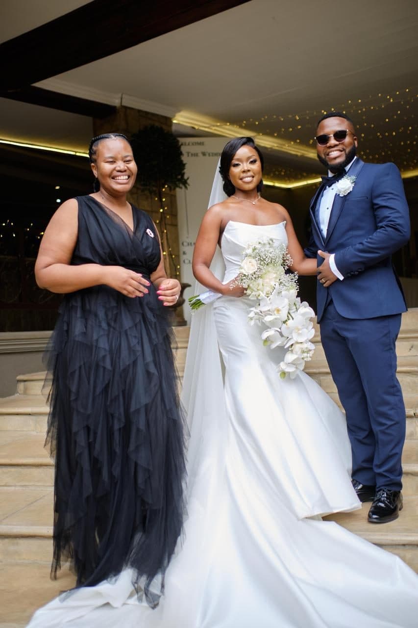 Kuhle's event planner alongside the bride and groom on the venue steps