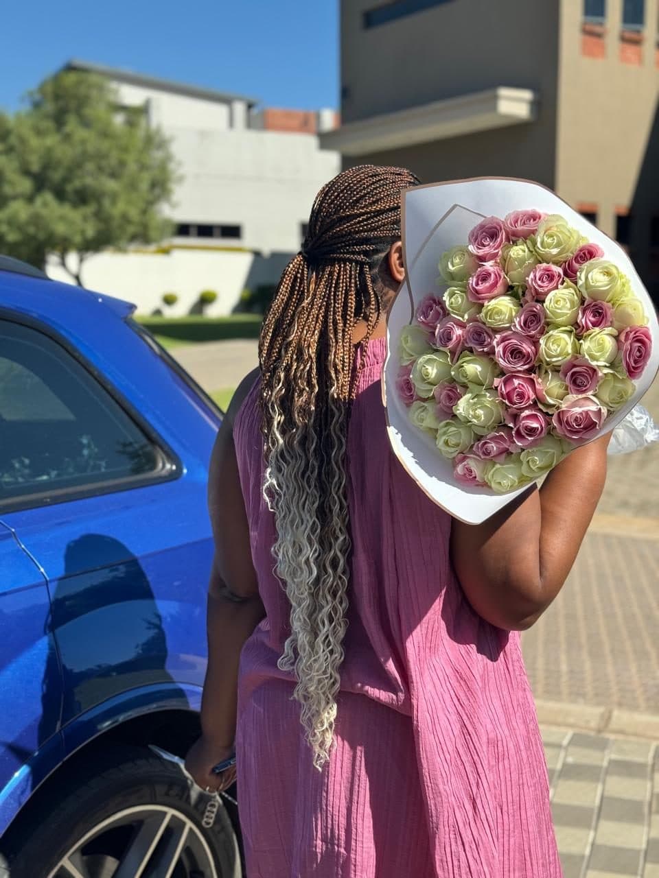 A hand-tied bouquet of pink and ivory roses ready for delivery