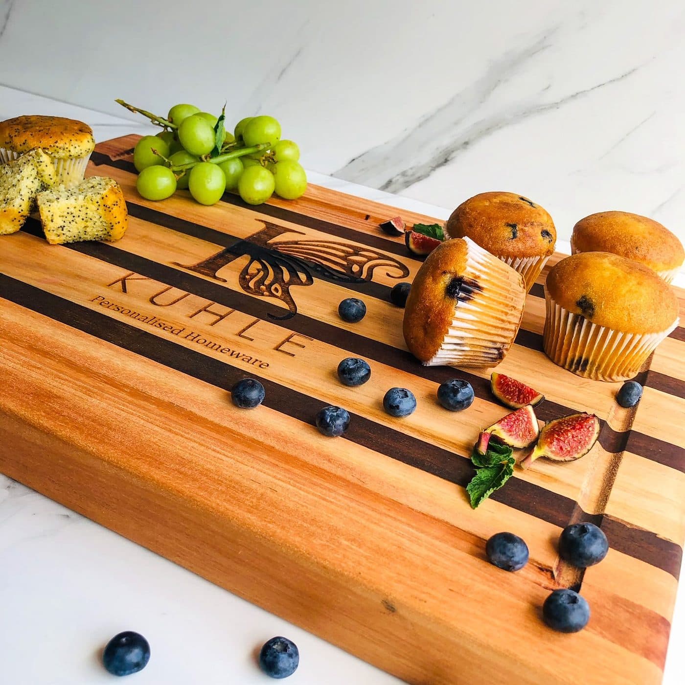 The striped Kuhle harvest board styled with poppyseed and blueberry muffins